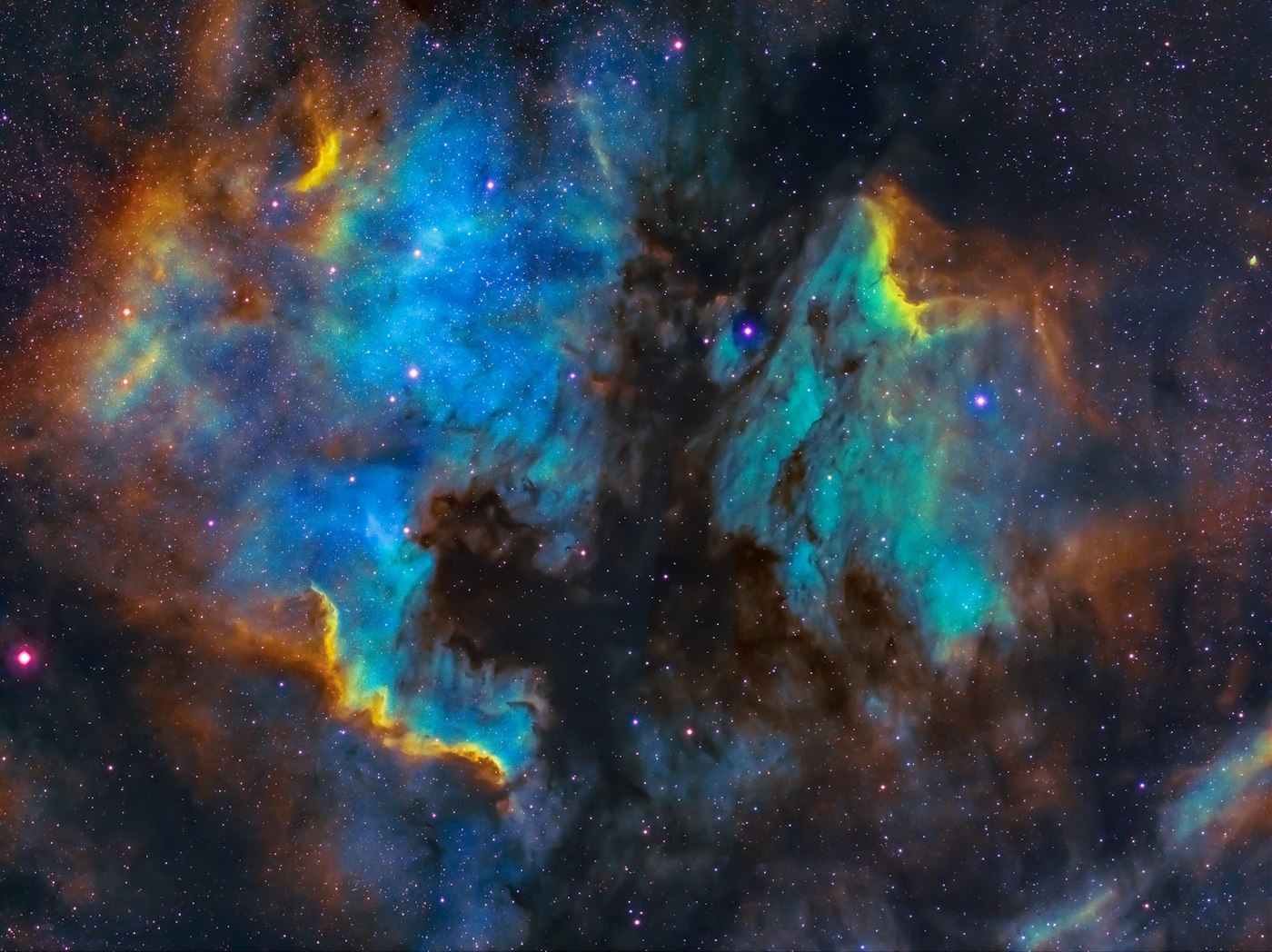 A richly coloured emission nebula in blues, golds and teals, the kind revealed by narrowband filters from light-polluted skies.